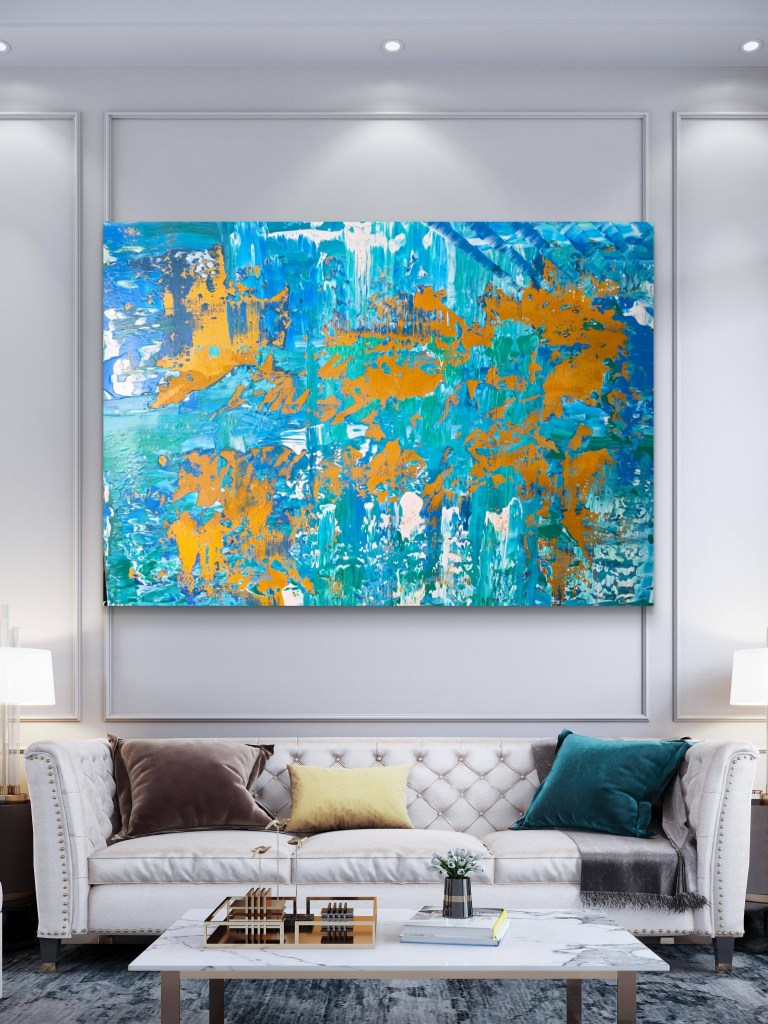 Goldene Strömung - ein Acrylbild in verschieden Blautönen, Weiß und Gold (der Rand ist teilweise mit Blattgold versehen) über einem weißen Sofa